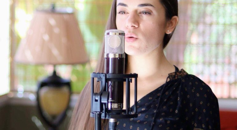 The Vanguard V13 Gen2 tube microphone offers warm and detailed recordings. In this image, a lady sings into the microphone using one of 9 polar pick up patterns. 